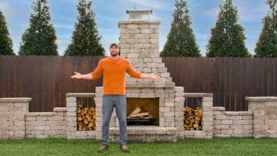 Jake standing in front of a deluxe estate outdoor fireplace for scale.