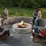 People gathered around a fire pit with a curved seat wall.
