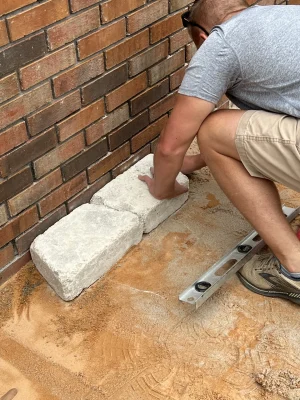DIY levels the first course of block for its foundation.