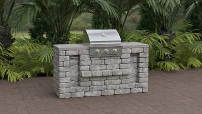 Small outdoor gas grill island kit on red pavers.