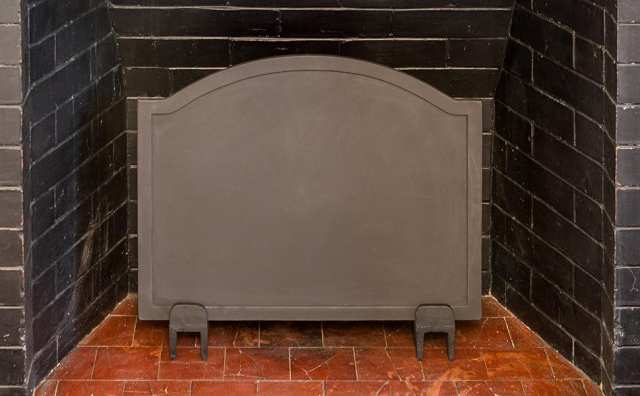 A cast iron fireback can help hold and radiate more of your fireplace's heat forward